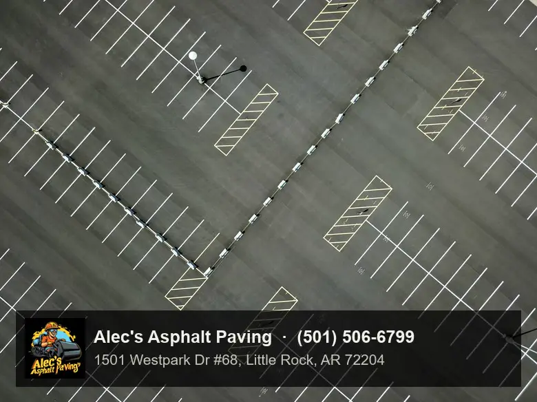 A parking lot seen from directly above, with white stall lines and hatched islands