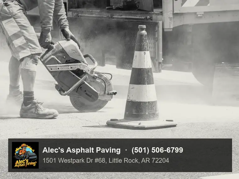A worker in hi-vis cutting through asphalt with a cut-off saw beside a traffic cone, dust rising, a work truck behind