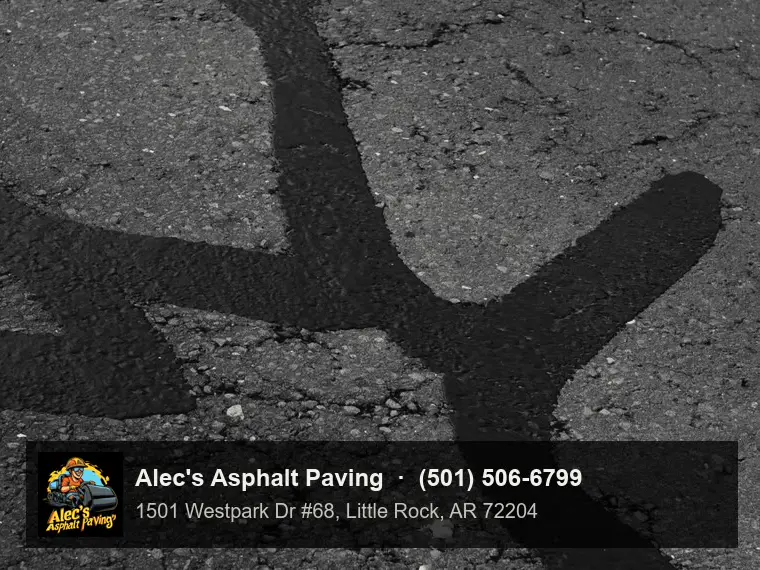 Close view of worn asphalt where a branching network of cracks has been sealed with wide, smooth bands of crack sealant