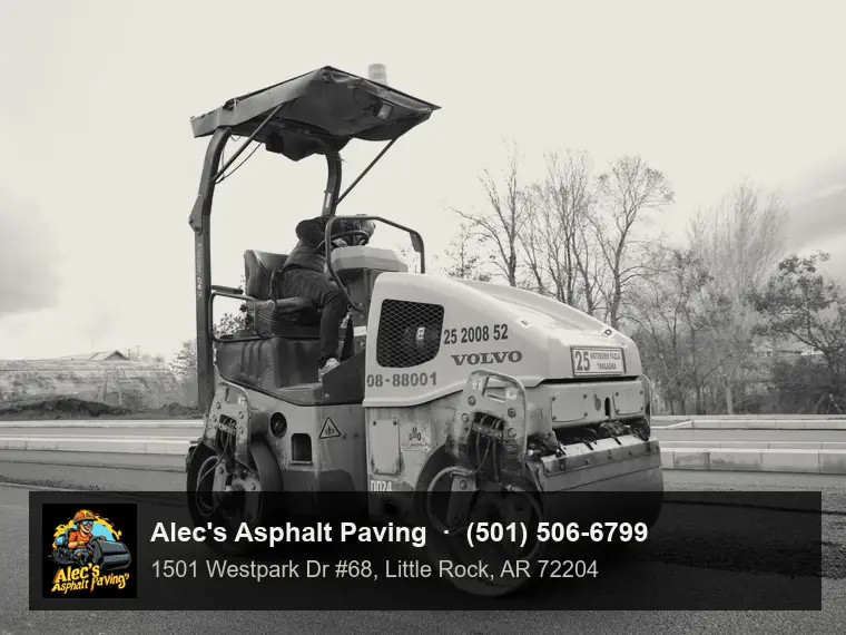 A tandem steel-drum roller compacting fresh hot-mix asphalt, operator in the seat