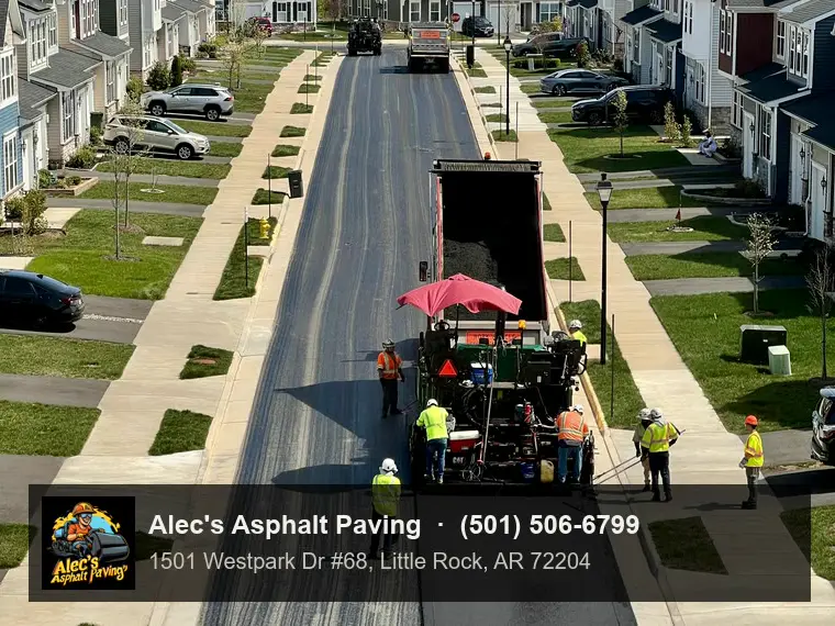 Looking down on a residential street mid-resurfacing, the grooved milled lane on the left beside a lane of fresh smooth black asphalt