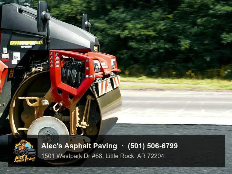 A close view of a roller drum pressing down fresh asphalt